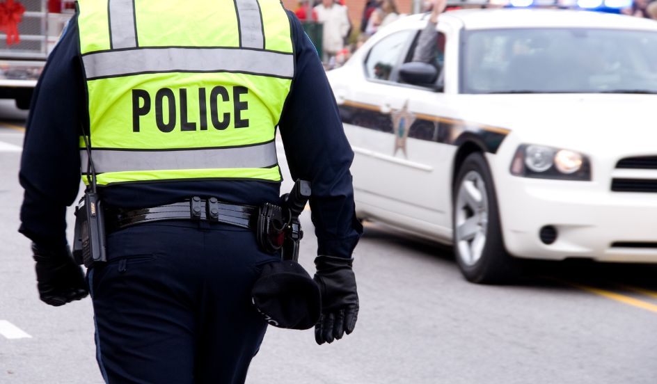 police officer walking towards police car