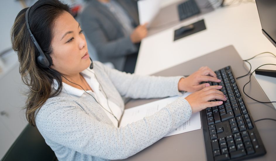 medical transcriptionist typing with headphones on