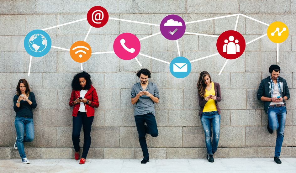 people standing against a wall with smartphones in hands with floating icons above