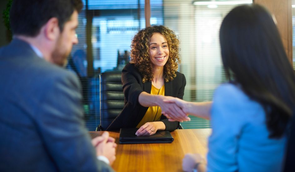 woman smiling shaking hands at an interview