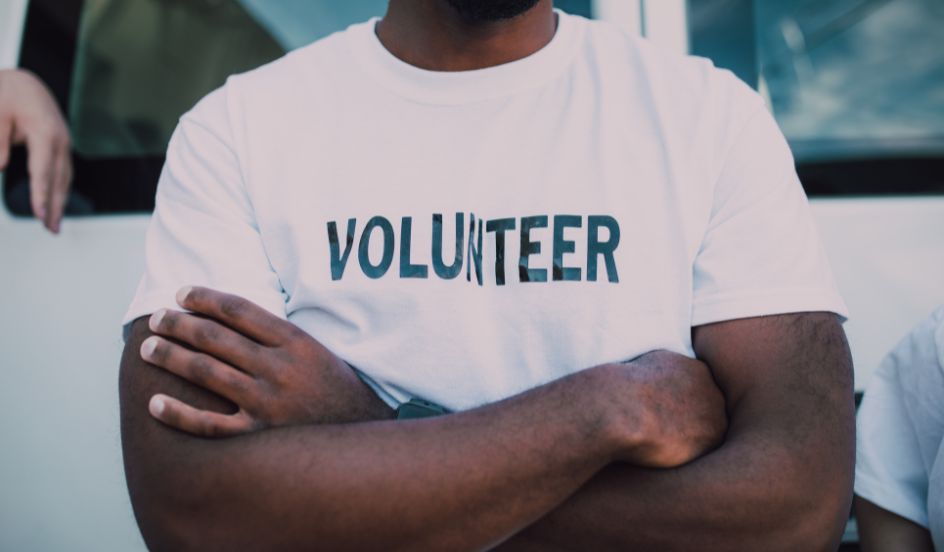 male volunteer wearing a shirt with the word volunteer written on it