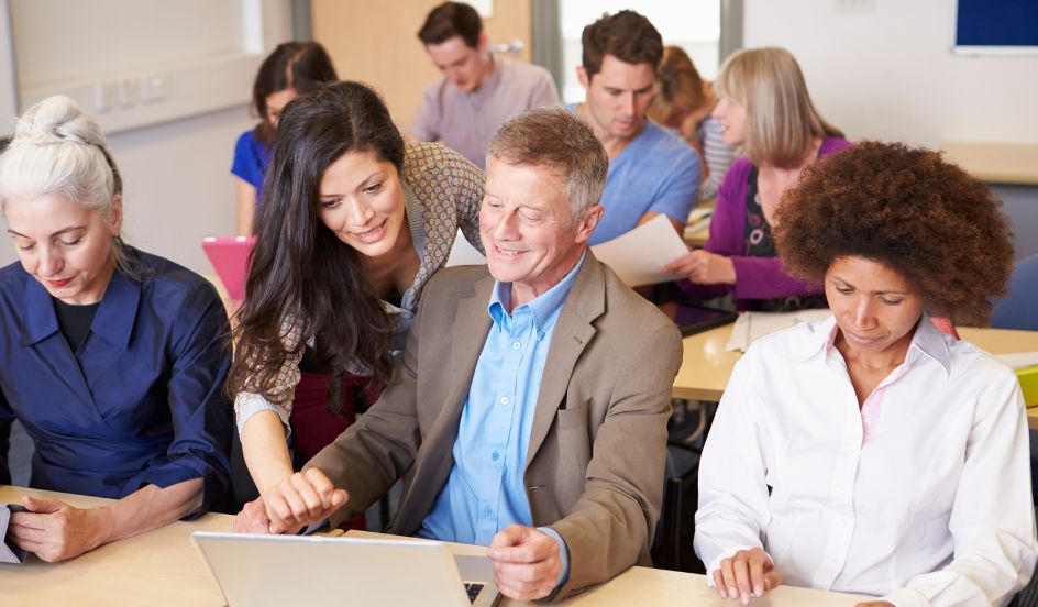 mature male student getting help from instructor