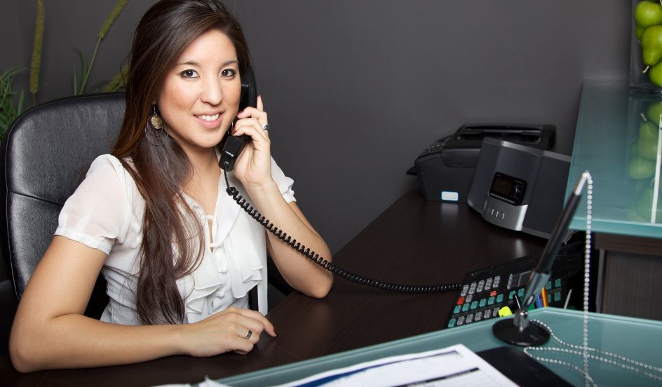 administrative assistant on telephone at desk