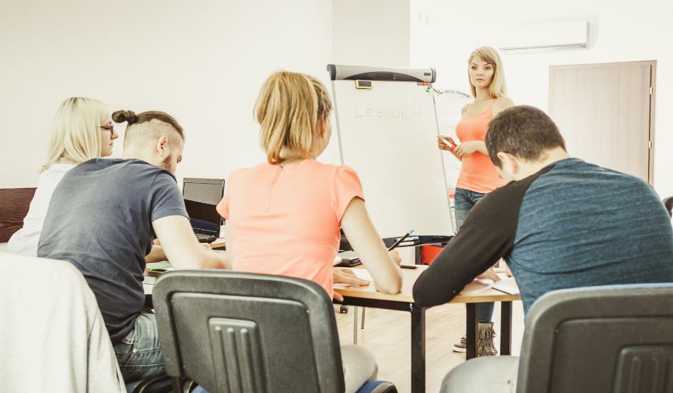 female instructor in front of class of adult students