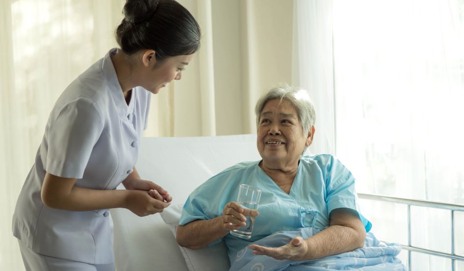 female psw helping female senior in bed