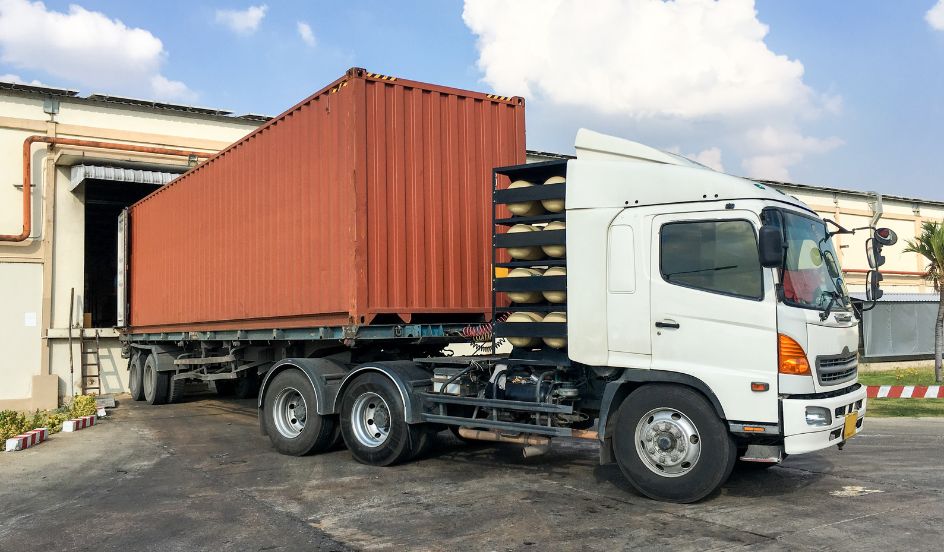truck-with-shipping-container-backing-into-shipping-bay