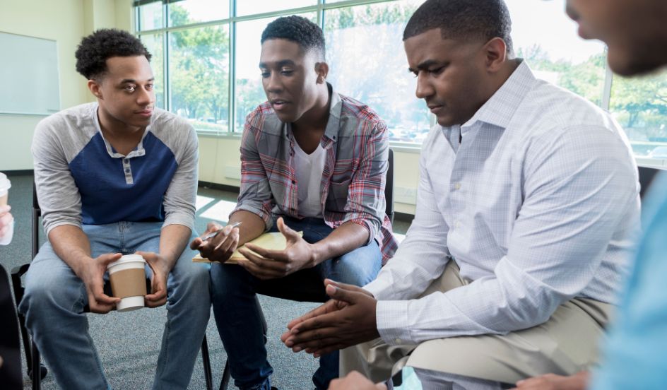 group of men sitting together addiction support