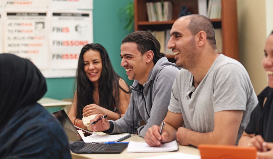 mature students sitting at table laughing