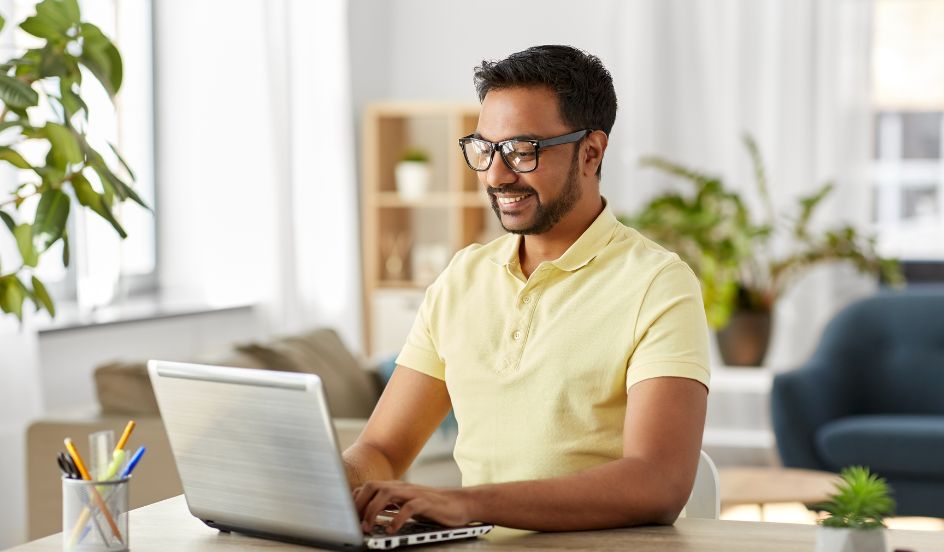 male sitting at desk working on laptop