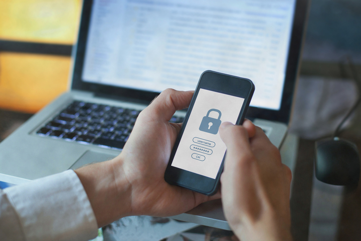 hands holding a smartphone with a lock on the screen