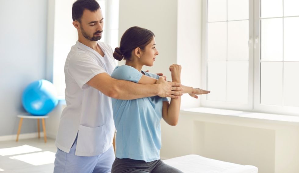 physiotherapy assistant helping a client with therapy