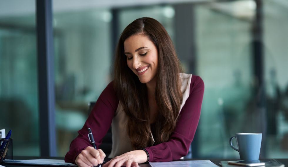 An office administrator takes notes during a meeting.