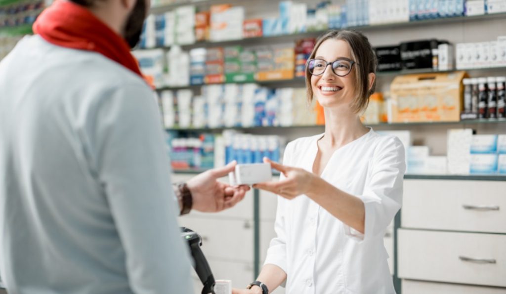 Um assistente de farmácia ajudando um cliente