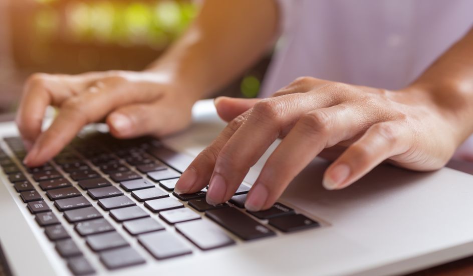 hands typing on laptop keyboard for online learning