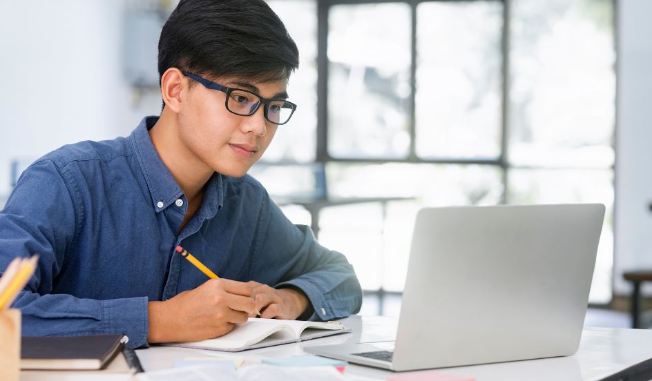 online learning student sitting in front of a laptop