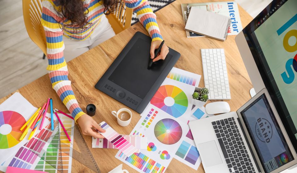 woman sitting at a desk with colour wheels and design templates